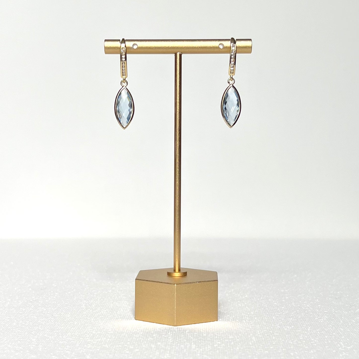 This earring pair features a crystal blue glass marquise bezel charm hung on a gold filled CZ channel set French hook earring.