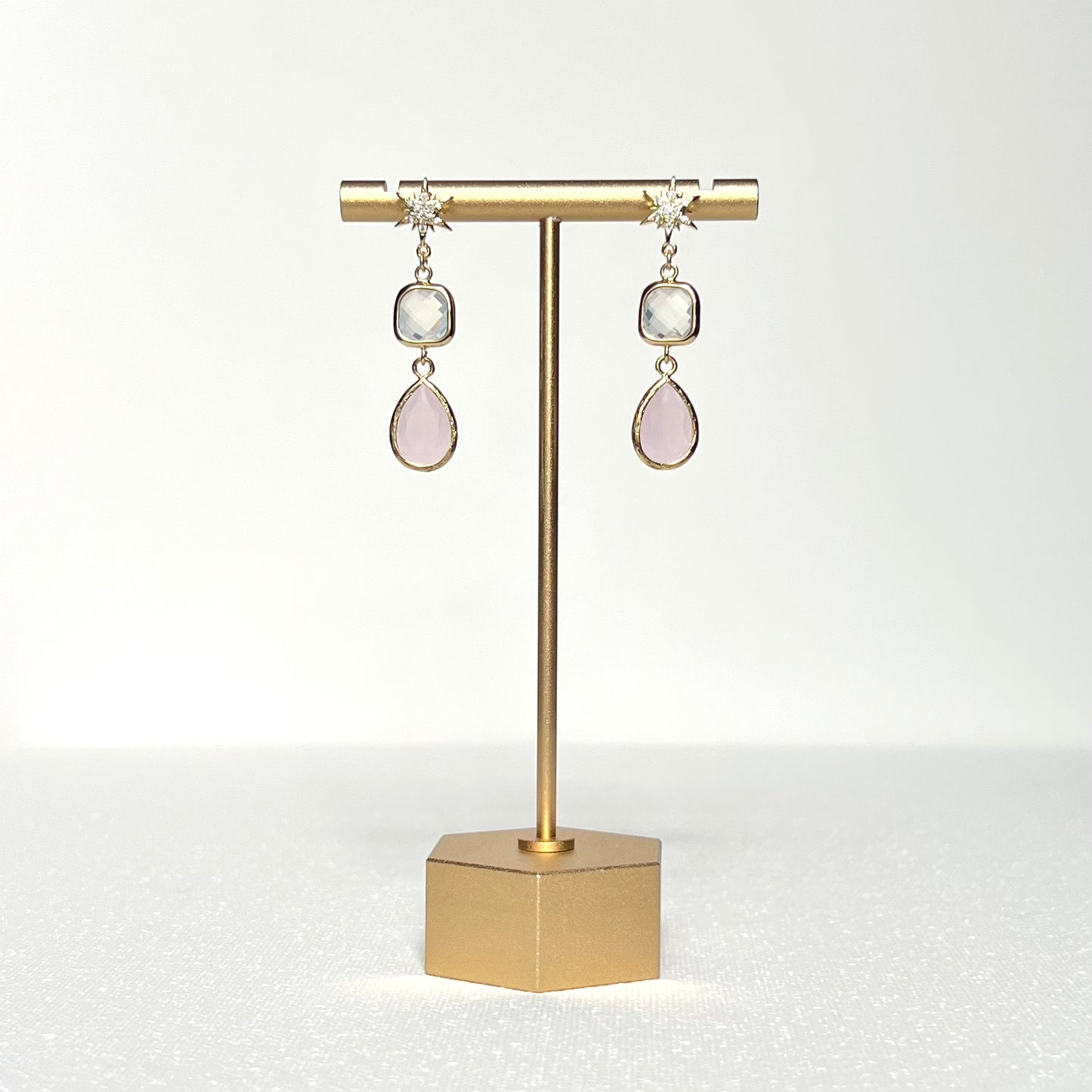This earring set features a white square glass bezel charm with a pink glass teardrop shape bezel charm hung by a CZ crested gold filled star shaped earring post.